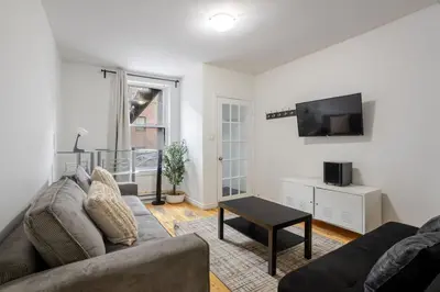 a living room with a couch and a tv at Spectacular 2B unit in Montreal in Montréal