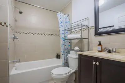 a bathroom with a toilet and a tub and a sink at Spectacular 2B unit in Montreal in Montréal