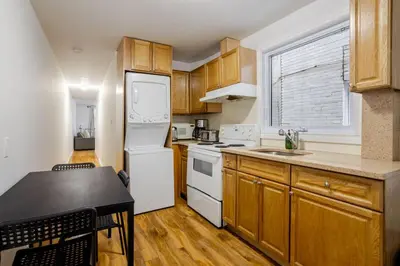 a kitchen with wooden cabinets and a white refrigerator at Spectacular 2B unit in Montreal in Montréal