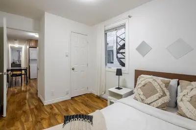 a white bedroom with a bed and a table at Spectacular 2B unit in Montreal in Montréal