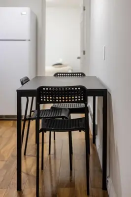 a black table with two chairs and a refrigerator at Spectacular 2B unit in Montreal in Montréal