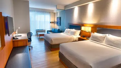 a hotel room with two beds and a desk at Holiday Inn Express & Suites Vaudreuil-Dorion by IHG in Vaudreuil-Dorion
