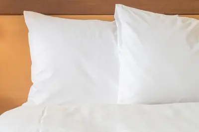 a bed with white sheets and pillows on it at Holiday Inn Express & Suites Vaudreuil-Dorion by IHG in Vaudreuil-Dorion