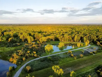 an aerial view of a park with a river and trees at Chalet 1 cuisine - Domaine de l'Archipel in Sorel