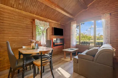 a living room with a table and a couch at Chalet 1 cuisine - Domaine de l'Archipel in Sorel