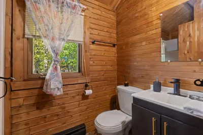 a bathroom with a toilet and a sink and a window at Chalet 1 cuisine - Domaine de l'Archipel in Sorel