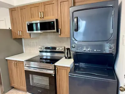 a kitchen with a stainless steel stove and microwave at Chic 3BR 5 Beds 5min walk to Metro Free Parking in Laval