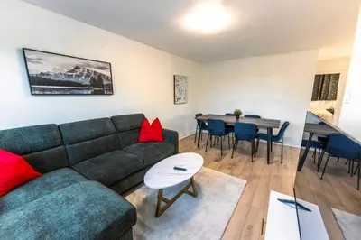 a living room with a couch and a table at Chic 3BR 5 Beds 5min walk to Metro Free Parking in Laval