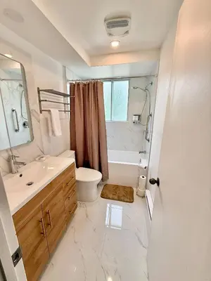 a bathroom with a sink and a toilet and a shower at Chic 3BR 5 Beds 5min walk to Metro Free Parking in Laval
