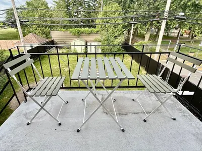 a picnic table and two chairs on a balcony at Chic 3BR 5 Beds 5min walk to Metro Free Parking in Laval
