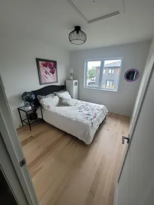 a bedroom with a large bed and a window at Longueuil homestay in Longueuil