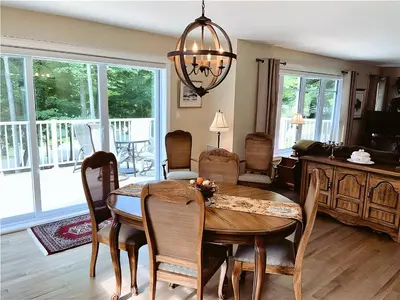 a dining room with a table and chairs at Cozy Stay with Balcony, BBQ & Trails, Near Lake Lyster in Coaticook