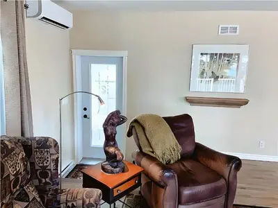 a living room with a couch and a chair at Cozy Stay with Balcony, BBQ & Trails, Near Lake Lyster in Coaticook
