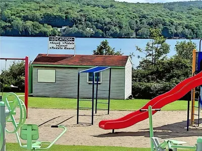 a playground with a slide in front of a building at Cozy Stay with Balcony, BBQ & Trails, Near Lake Lyster in Coaticook