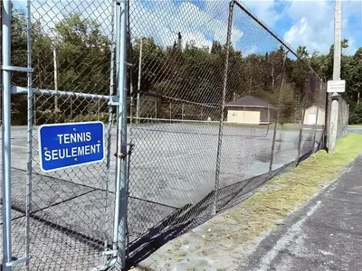 a fence with a sign that reads teams spill istg at Cozy Stay with Balcony, BBQ & Trails, Near Lake Lyster in Coaticook
