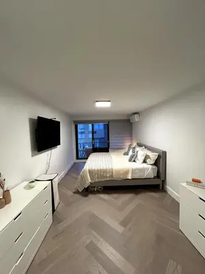 a bedroom with a bed and a flat screen tv at Elegant Downtown Retreat with Balcony & Parking in Montréal