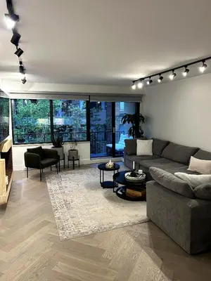 a living room with a couch and a table at Elegant Downtown Retreat with Balcony & Parking in Montréal