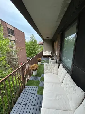 a balcony with white couches on a building at Elegant Downtown Retreat with Balcony & Parking in Montréal