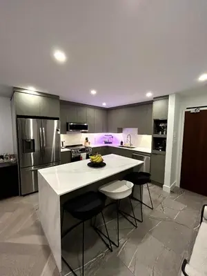 a kitchen with a large white island in a kitchen at Elegant Downtown Retreat with Balcony & Parking in Montréal