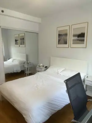 a bedroom with a large white bed and a mirror at Cozy 1BDR in Prime location - Walk to Everything in Montréal