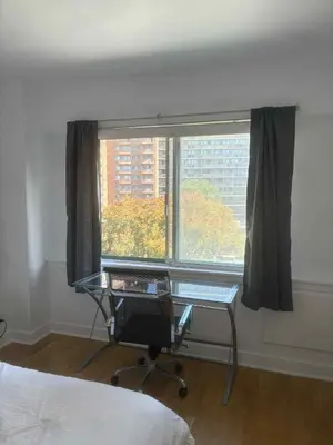 a bedroom with a desk in front of a window at Cozy 1BDR in Prime location - Walk to Everything in Montréal