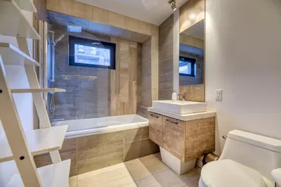 a bathroom with a toilet and a tub and a sink at Condo McGill University in Montréal
