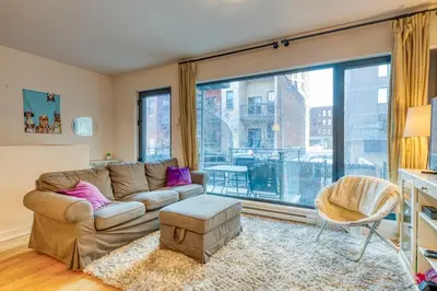 a living room with a couch and a large window at Condo McGill University in Montréal