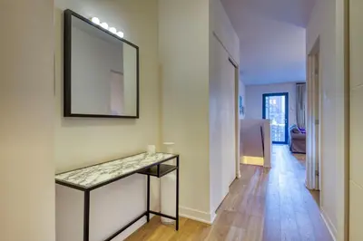a hallway with a table and a mirror on a wall at Condo McGill University in Montréal