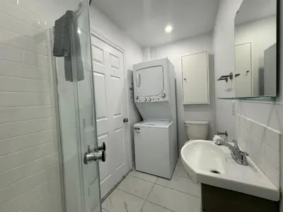 a white bathroom with a sink and a washing machine at Appartement simple ou double 2313#1M in Montréal