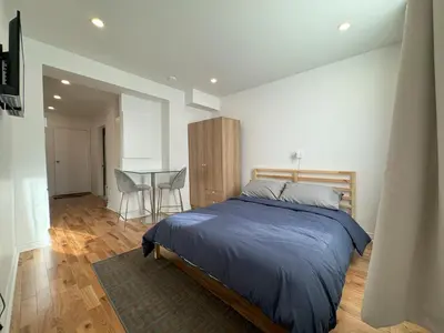 a bedroom with a bed and a table with chairs at Appartement simple ou double 2313#1M in Montréal
