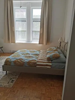a bed sitting in a bedroom with a window at Grand Appartement centre-ville 1227, 3 chambres in Montréal
