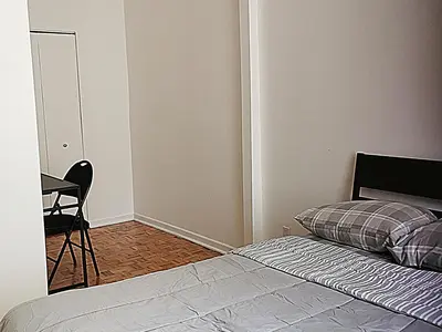 a bedroom with a bed and a chair and a table at Appartement centre-ville Montréal 1215 LT in Montréal