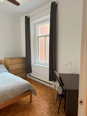 a bedroom with a bed and a desk and a window at Magnifique 3 chambres Centre ville 1217 in Montréal