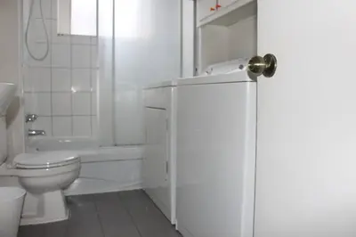 a white bathroom with a toilet and a sink at Magnifique 3 chambres Centre ville 1217 in Montréal