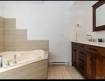 a white bathroom with a tub and a sink at Spacious 4-Bdr Retreat in Charming Ste-Rose, Laval in Laval