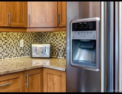a kitchen with a stainless steel refrigerator and a microwave at Spacious 4-Bdr Retreat in Charming Ste-Rose, Laval in Laval