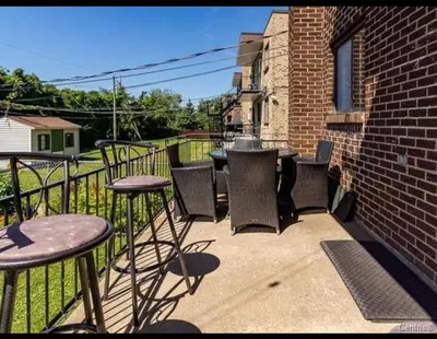a patio with tables and chairs on a balcony at Spacious 4-Bdr Retreat in Charming Ste-Rose, Laval in Laval