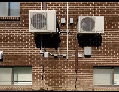two air conditioners on the side of a brick building at Spacious 4-Bdr Retreat in Charming Ste-Rose, Laval in Laval
