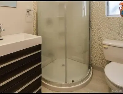 a bathroom with a shower and a toilet and a sink at Spacious 4-Bdr Retreat in Charming Ste-Rose, Laval in Laval