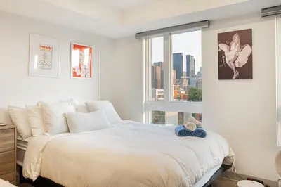 a bedroom with a large bed and a window at Top Location - Cozy & Bright MTL studio near metro in Montréal