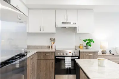 a kitchen with white cabinets and a stove top oven at Top Location - Cozy & Bright MTL studio near metro in Montréal
