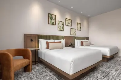 a hotel room with two beds and a chair at Hotel Railwayparc Montreal, Tapestry Collection By Hilton in Montréal