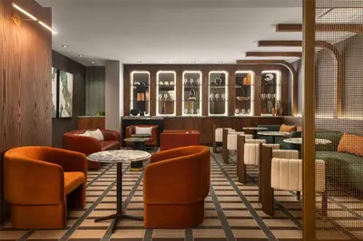 a bar with orange chairs and tables in a restaurant at Hotel Railwayparc Montreal, Tapestry Collection By Hilton in Montréal