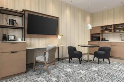 a hotel room with a tv and a table and chairs at Hotel Railwayparc Montreal, Tapestry Collection By Hilton in Montréal