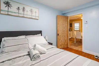 a bedroom with a large bed with towels on it at Appartement moderne 3 chambres avec spa, jardin privé & parking gratuit - accès autonome in Saint-Jean-sur-Richelieu