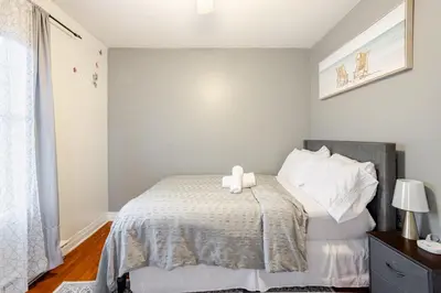 a bedroom with a bed with two towels on it at Appartement moderne 3 chambres avec spa, jardin privé & parking gratuit - accès autonome in Saint-Jean-sur-Richelieu