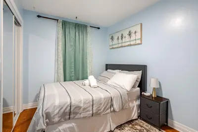 a bedroom with a bed and a window at Appartement moderne 3 chambres avec spa, jardin privé & parking gratuit - accès autonome in Saint-Jean-sur-Richelieu