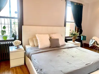 a bedroom with a large bed with two windows at Beautiful Sunny big apartment in Montréal
