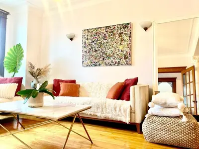 a living room with a couch and a painting on the wall at Beautiful Sunny big apartment in Montréal