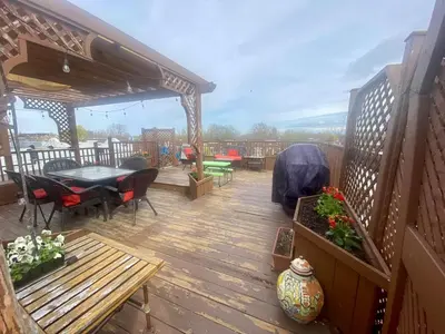 a wooden deck with a table and chairs on it at Beautiful Sunny big apartment in Montréal
